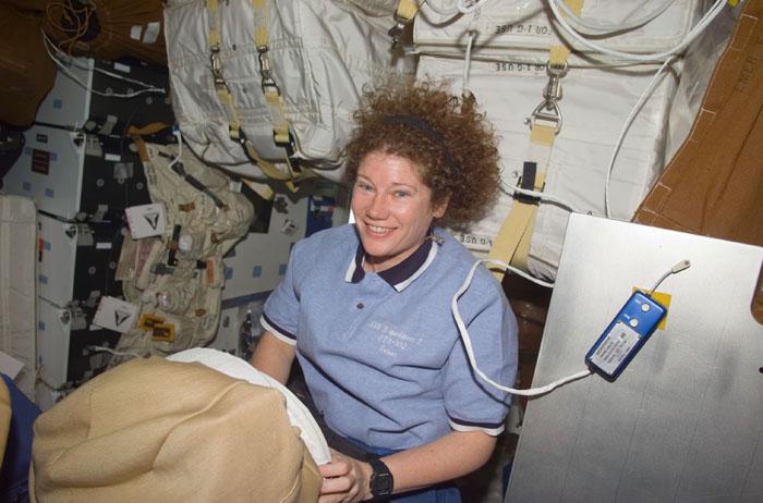 STS102-E-5048  (10 March 2001) --- Astronaut Susan J. Helms, STS-102 mission specialist, looks over some supplies on the mid deck.  Helms is one of two astronauts assigned to space walk duties after the Space Shuttle Discovery and the International Space Station (ISS) link in Earth orbit. The photograph was recorded with a digital still camera.