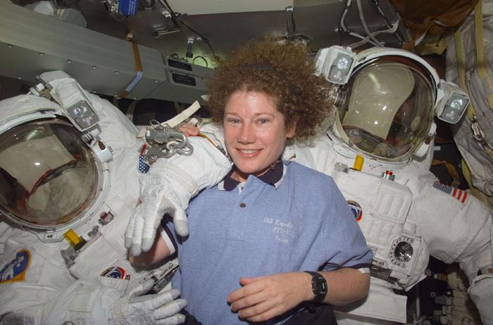 TS102-E-5054  (10 March 2001) --- Astronaut Susan J. Helms, STS-102 mission specialist, is pictured on the mid deck with both Extravehicular Mobility Unit (EMU) space suits designated for extravehicular activity (EVA).  Helms is one of two astronauts assigned to space walk duties after the Space Shuttle Discovery and the International Space Station (ISS) link in Earth orbit.  The photograph was recorded with a digital still camera.
