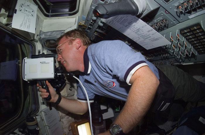 STS102-E-5064  (10 March 2001) --- Astronaut Andrew S.W. Thomas, STS-102 mission specialist, uses a laser ranging device on aft flight deck of the Space Shuttle Discovery. This instrument is a regularly called-on tool during rendezvous operations with the International Space Station (ISS).  The photograph was recorded with a digital still camera.
