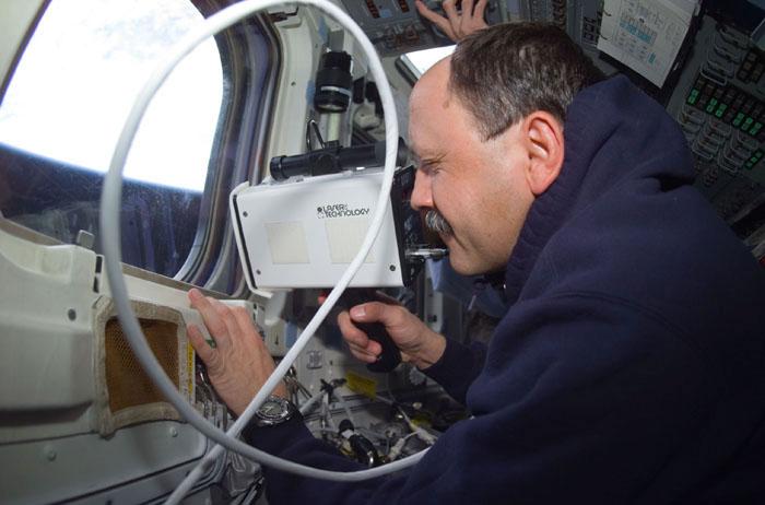 STS102-E-5085 (10 March 2001)  --- Cosmonaut Yury V. Usachev, STS-102 mission specialist, uses a laser ranging device on  Discovery's aft flight deck during rendezvous operations. The photograph was recorded with a digital still camera.