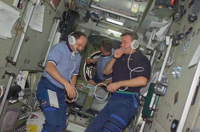 STS102-E-5102 (10 March 2001) ---  Left to right, cosmonaut Yury V. Usachev, astronaut James S. Voss and cosmonaut Yuri P. Gidzenko visit on the International Space Station soon after hatches were open between the Discovery and the station.  Gidzenko, Soyuz commander on the Expedition One crew, will be returning with the STS-102 crew aboard Discovery after having been onboard the orbiting outpost since early November of 2000.  Usachev, Expedition Two commander, along with astronauts  Voss and Susan J. Helms are taking over the station for a lengthy stay. The photograph was recorded with a digital still camera.