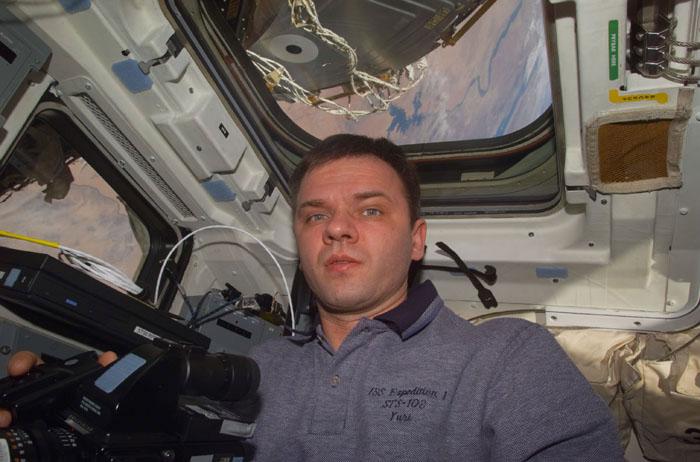 STS102-E-5138 (12 March 2001) --- Cosmonaut Yuri P. Gidzenko, now a member of the STS-102 crew, on Discovery's flight deck. Lake Nasser, in Egypt, can be seen through the overhead flight deck window in the background. Gidzenko, representing Rosaviakosmos, had been onboard the International Space Station (ISS) since early November 2000. The photograph was taken with a digital still camera.