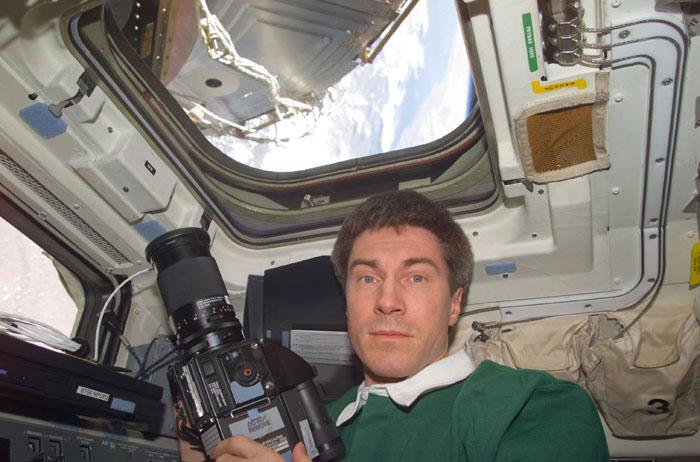 STS102-E-5139 (12 March 2001) --- Cosmonaut Sergei K. Krikalev, now a member of the STS-102 crew, prepares to use a camera on Discovery's flight deck. Krikalev, representing Rosaviakosmos, had been onboard the International Space Station (ISS) since early November 2000.  The photograph was taken with a digital still camera.