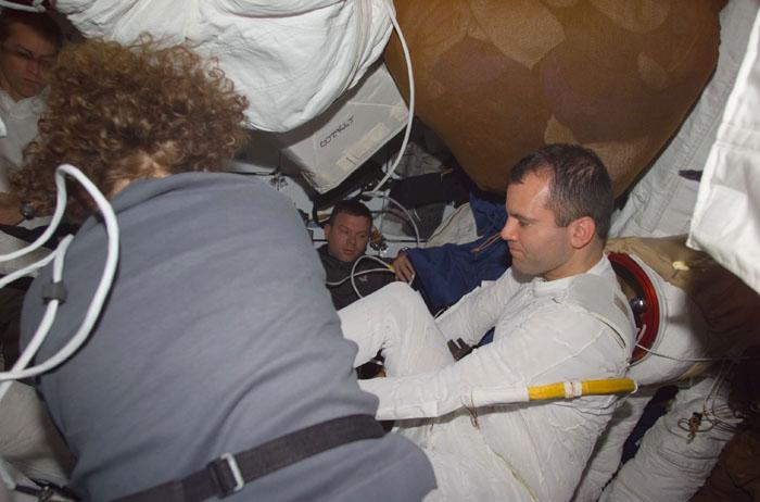 STS102-E-5162 (13 March 2001) --- Astronaut Susan J. Helms assists astronaut Paul W. Richards, mission specialist, during suit donning on Discovery's mid deck.  Shortly afterward,Richards joined astronaut Andrew S.W. Thomas for the second STS-102 space walk.