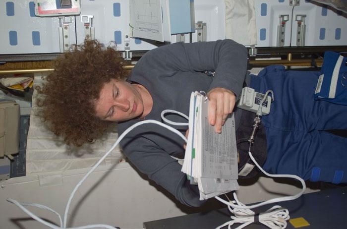 STS102-E-5208 (13 March 2001) --- Astronaut Susan J. Helms enters notes on the mid deck of the Space Shuttle Discovery. The photograph was taken with a digital still camera.