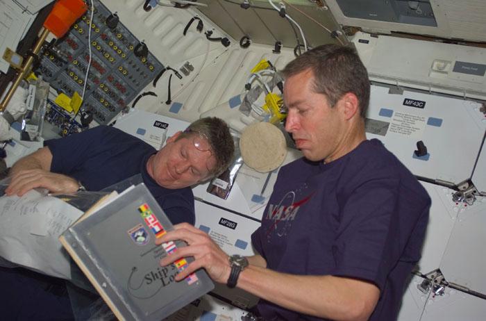 STS102-E-5234 (17 March 2001) --- On Discovery's mid deck, astronauts William M. (Bill) Shepherd  (left) and James D. Wetherbee discuss events of the joint activities among  shuttle and station crew members.  Wetherbee, STS-102 commander, looks over the ship's log with the outgoing station commander. The image was recorded with a digital still camera.