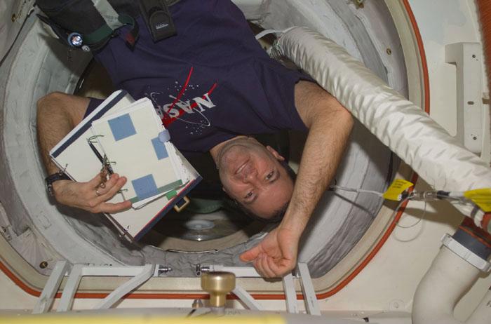 STS102-E-5235 (17 March 2001) --- Astronaut Paul W. Richards,  mission specialist, totes a clip board and a notebook as he passes through a hatchway.  Richards, along with his STS-102 crew mates, joined the International Space Station (ISS) crew members in moving supplies.  The image was recorded with a digital still camera.