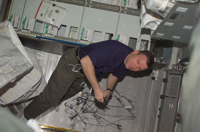 STS102-E-5244 (17 March 2001) --- Astronaut James M. Kelly, STS-102 pilot, sets up laboratory racks in the Destiny module onboard the Inernational Space Station (ISS).  The photo was taken with a digital still camera.
