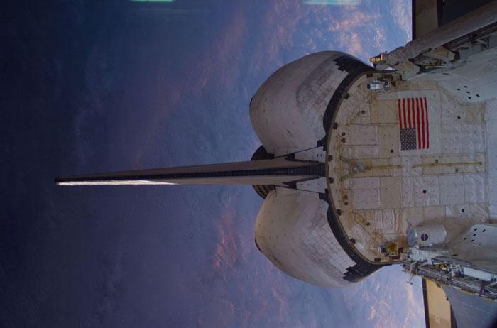 STS102-E-5276 (17 March 2001) --- This scene of the aft portion of the Space Shuttle Discovery, backdropped against a massive cloud cover on Earth, was recorded with a digital still camera from inside the International Space Station (ISS) while the two spacecraft were linked together to accomplish more work on the station and exchange crew personnel assigned to man it.
