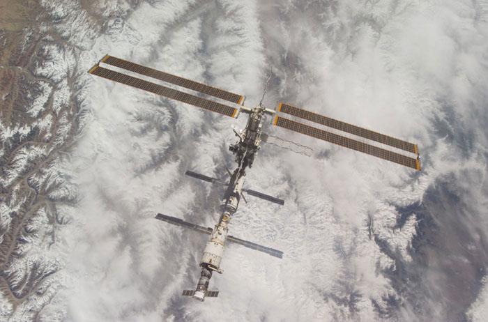 STS102-E-5323 (18 March 2001) --- The International Space Station (ISS) backdropped against clouds and snow-covered mountains was photographed with a digital still camera from the Space Shuttle Discovery on March 18, 2001.  It is a standard operation for the shuttle to make a final fly-around of the outpost following unlinking from it. A new crew comprised of cosmonaut Yury V. Usachev and astronauts James S. Voss and Susan J. Helms will spend several months aboard the station.