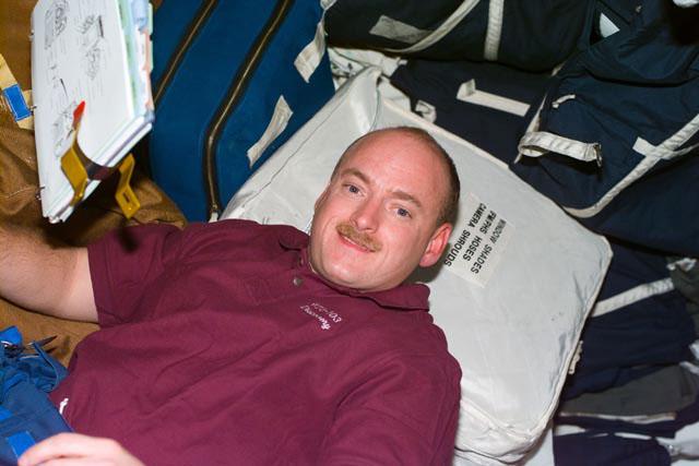 S103-E-5006 (20 December 1999) --- Astronaut Scott J. Kelly, pilot, sorts out some of the supplies for the STS-103 mission during flight day 1 activity onboard Discovery.  The photo was taken with an electronic still camera (ESC) at  16:11:59 GMT, Dec. 20, 1999.