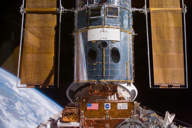 S103-E-5156 (21 December 1999) --- This electronic still camera's view and others in this series showing the Hubble Space Telescope (HST) being berthed in Discovery's bay were recorded during and soon after capture; and they were downlinked  at the completion of the mission's first space walk on the following day by the busy STS-103 astronauts. The image was recorded at 19:46:15 GMT, Dec. 21, 1999.