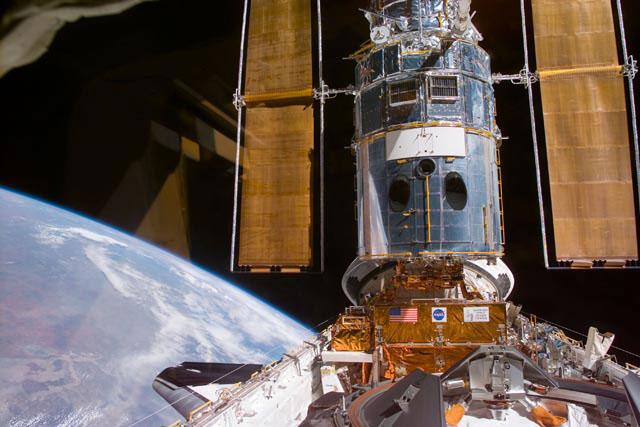 S103-E-5159 (21 December 1999) --- This electronic still camera's view and others in this series showing the Hubble Space Telescope (HST) being berthed in Discovery's bay were recorded during and soon after capture; and they were downlinked at the completion of the mission's first space walk on the following day by the busy STS-103 astronauts. The image was recorded at 19:47:02 GMT, Dec. 21, 1999.