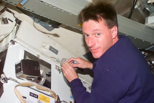 S103-E-5184 (21 December 1999) --- Astronaut C. Michael Foale, mission specialist, performs a minor maintenance task on the mid deck of the Earth-orbiting Space Shuttle Discovery.  The long rectangular structure near Foale's head is the escape pole, which has been standard equipment on the shuttle fleet since 1988.  The photo was recorded with an electronic still camera (ESC) at 10:39:31 GMT, Dec. 21, 1999.