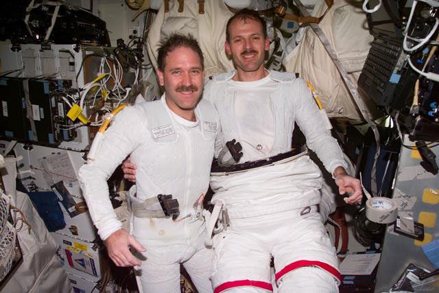 S103-E-5366 (24 December 1999) --- Astronauts John M. Grunsfeld (left), mission specialist, and Steven L. Smith, payload commander, are pictured prior to donning their extravehicular mobility unit (EMU) space suits onboard Discovery's mid deck. Hours later, the two completed the third and final space walk scheduled for NASA's third servicing mission to the Hubble Space Telescope (HST).