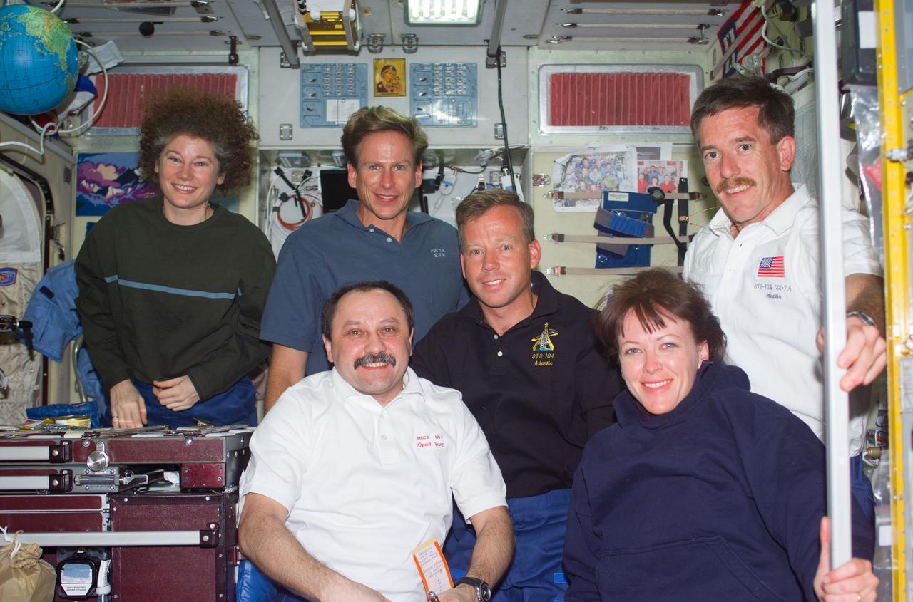 S104-E-5055 (14 July 2001) --- Soon after their ingress into the International Space Station (ISS), STS-104 crewmembers pose for a photograph with Expedition Two crewmembers in the Zvezda Service Module.  From left to right are: back row - Susan J. Helms, Expedition Two flight engineer; Michael L. Gernhardt, STS-104 mission specialist; Steven W. Lindsey, STS-104 mission commander; James F. Reilly, STS-104 mission specialist; front row - Yury V. Usachev, Expedition Two mission commander; and Janet L. Kavandi, STS-104 mission specialist.  Usachev represents Rosaviakosmos.