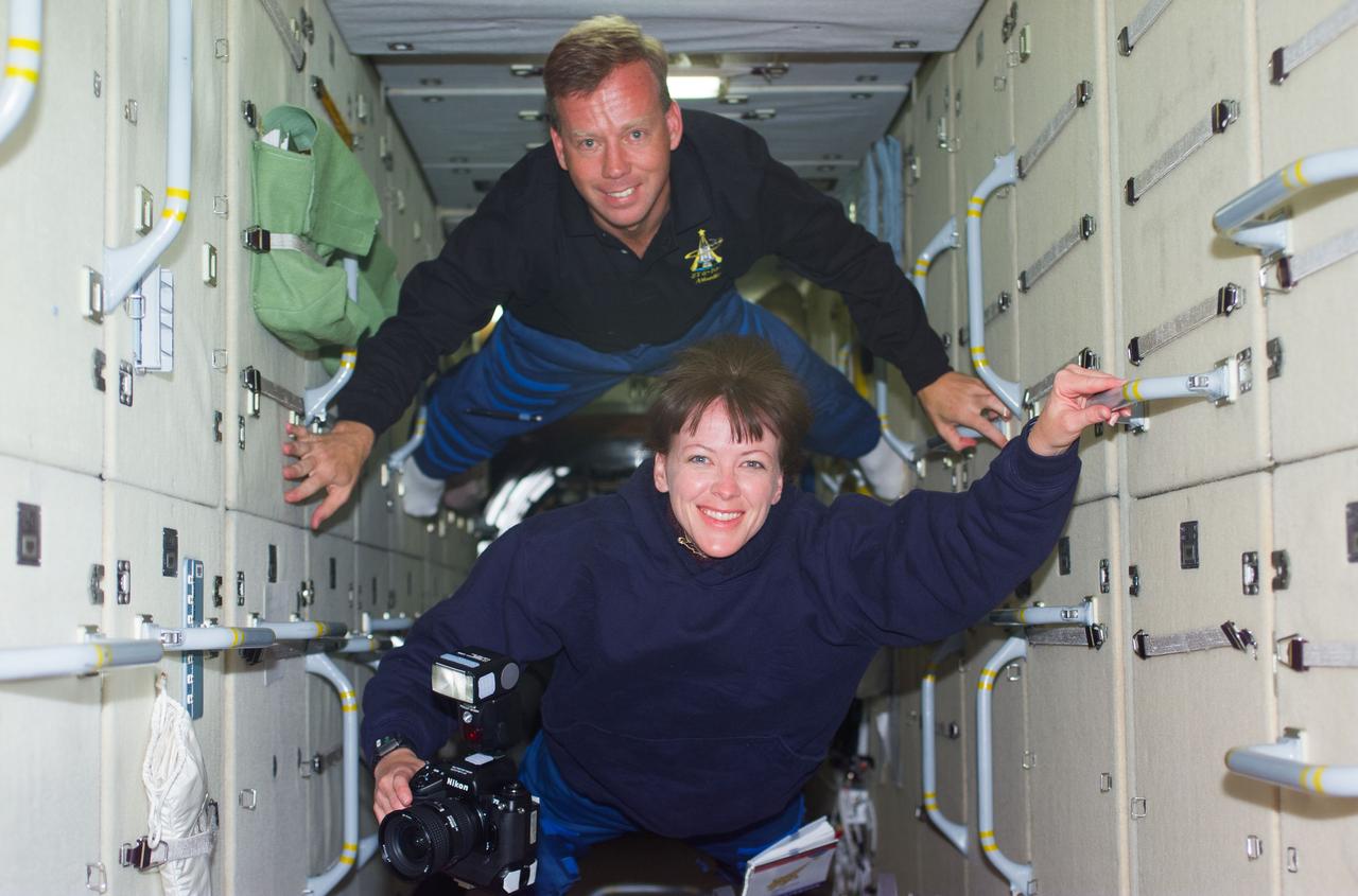 S104-E-5058 (14 July 2001) --- STS-104 crewmembers Steven W. Lindsey, mission commander, and Janet L. Kavandi, mission specialist, travel through the Zarya module during their visit to the International Space Station (ISS).