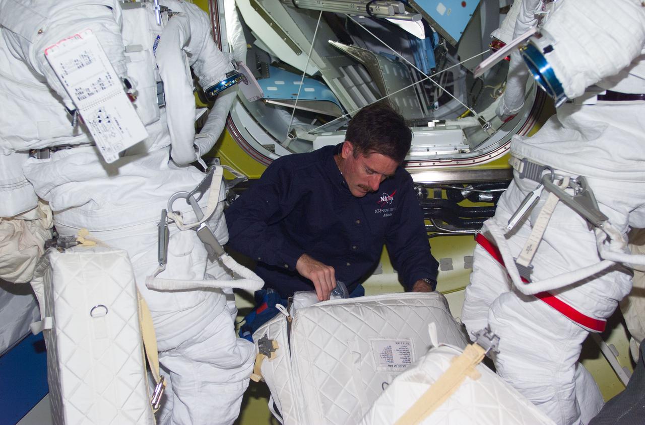 STS104-E-5166 (19 July 2001) --- Astronaut James F. Reilly, STS-104 mission specialist, looks over some supplies in the Quest Airlock aboard the International Space Station (ISS).  Reilly is one of two assigned space walkers on the STS-104 mission.  The third and final scheduled extravehicular activity (EVA) is to utilize the new airlock, marking its first ever usage.  The image was recorded with a digital still camera.