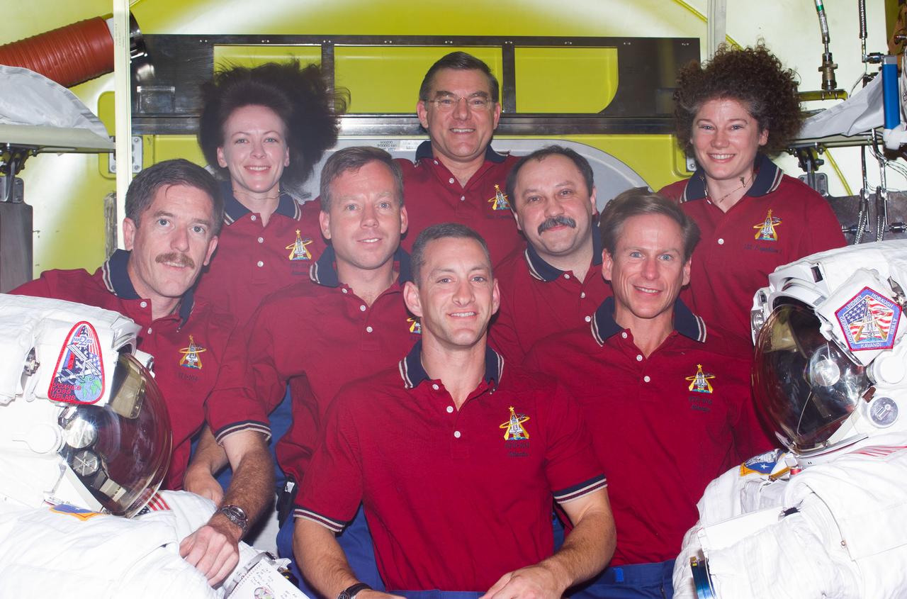 STS104-E-5177 (20 July 2001) --- Seven astronauts and a cosmonaut representing Rosaviakosmos take a break in joint activities involving the Expedition Two and STS-104 crews to pose for an in-flight portrait in the newly delivered Quest Airlock on the International Space Station (ISS). Flanked by two extravehicular mobility unit (EMU) space suits,  Charles O. Hobaugh is in front. On the second row are, from the left, James F. Reilly, Steven W. Lindsey, Yury V. Usachev and Michael L. Gernhardt. In the rear are  Janet L. Kavandi, James S. Voss and Susan J. Helms.  Usachev, commander; along with Voss and Helms, both flight engineers, comprise the Expedition Two crew.  Lindsey is STS-104  commander, with Hobaugh serving as pilot.  Kavandi, STS-104 flight engineer, is joined by Gernhardt and Reilly as mission specialists on the mission. This image was recorded with a digital still camera.