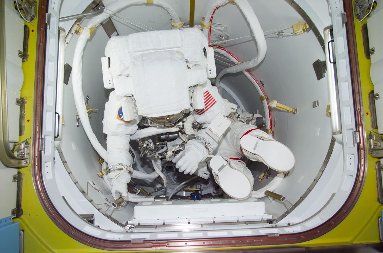 STS104-E-5201 (20 July 2001) --- Though it was a bit before Friday midnight in Houston, it was already into the morning hours of Saturday by Greenwich Mean Time (GMT) when astronauts James F. Reilly (left) and Michael L. Gernhardt were photographed with a digital still camera in the Crew Lock prior to depressurization of the compartment for the third and final space walk of STS-104.