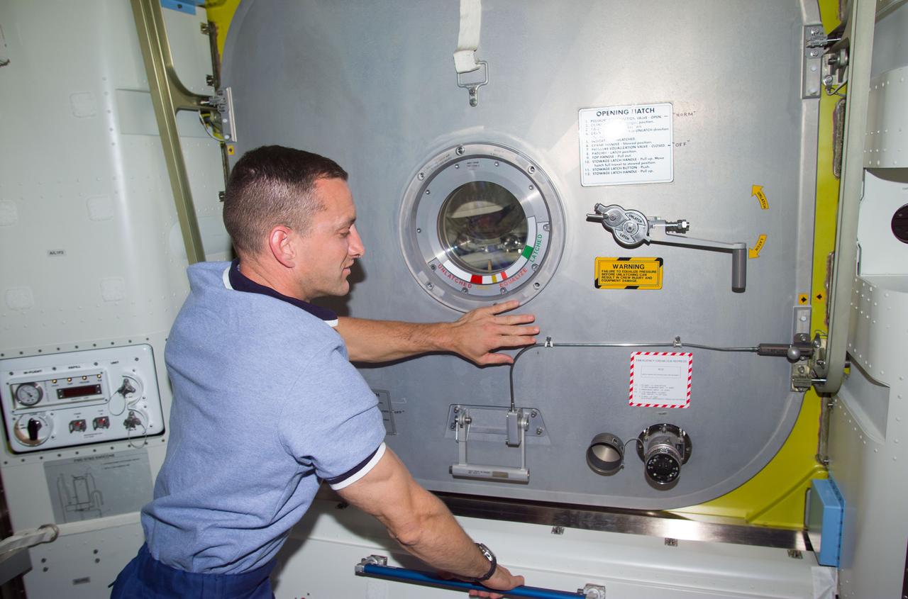 STS104-E-5206 (20 July 2001) --- The final closing of the Crew Lock hatch in the Airlock Quest was performed by astronaut Charles O. Hobaugh, pilot, prior to the start of the third and final STS-104 space walk.  The image was recorded with a digital still camera.