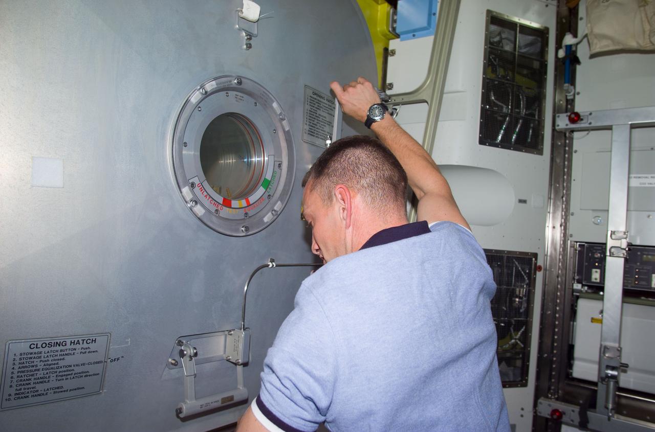 STS104-E-5208 (20 July 2001) --- The final closing of the Crew Lock hatch in the Airlock Quest was performed by astronaut Charles O. Hobaugh, pilot, prior to the start of the third and final STS-104 space walk.  The image was recorded with a digital still camera.