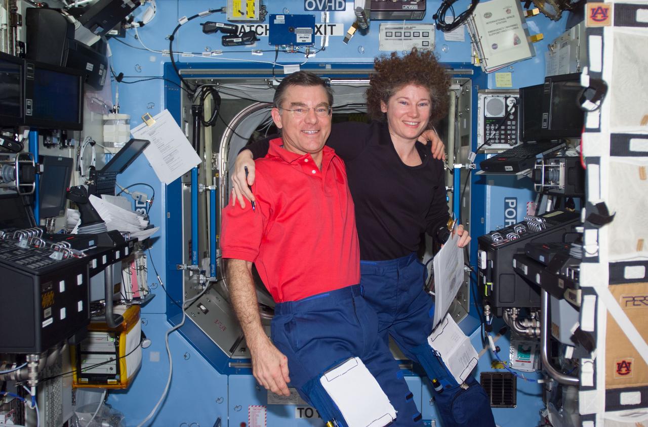 STS104-E-5223 (21 July 2001) --- A crew member used a digital still camera to take a picture of members of the Expedition Two crew in the Destiny laboratory. Within the final three weeks of their habitation aboard the International Space Station (ISS), astronauts James S. Voss and Susan J. Helms, flight engineers, both performed important maneuvers with the Canadarm2, Space Station Remote Manipulator System (SSRMS), during the STS-104 mission. Cosmonaut Yury V. Usachev, Expedition Two commander, is out of frame.