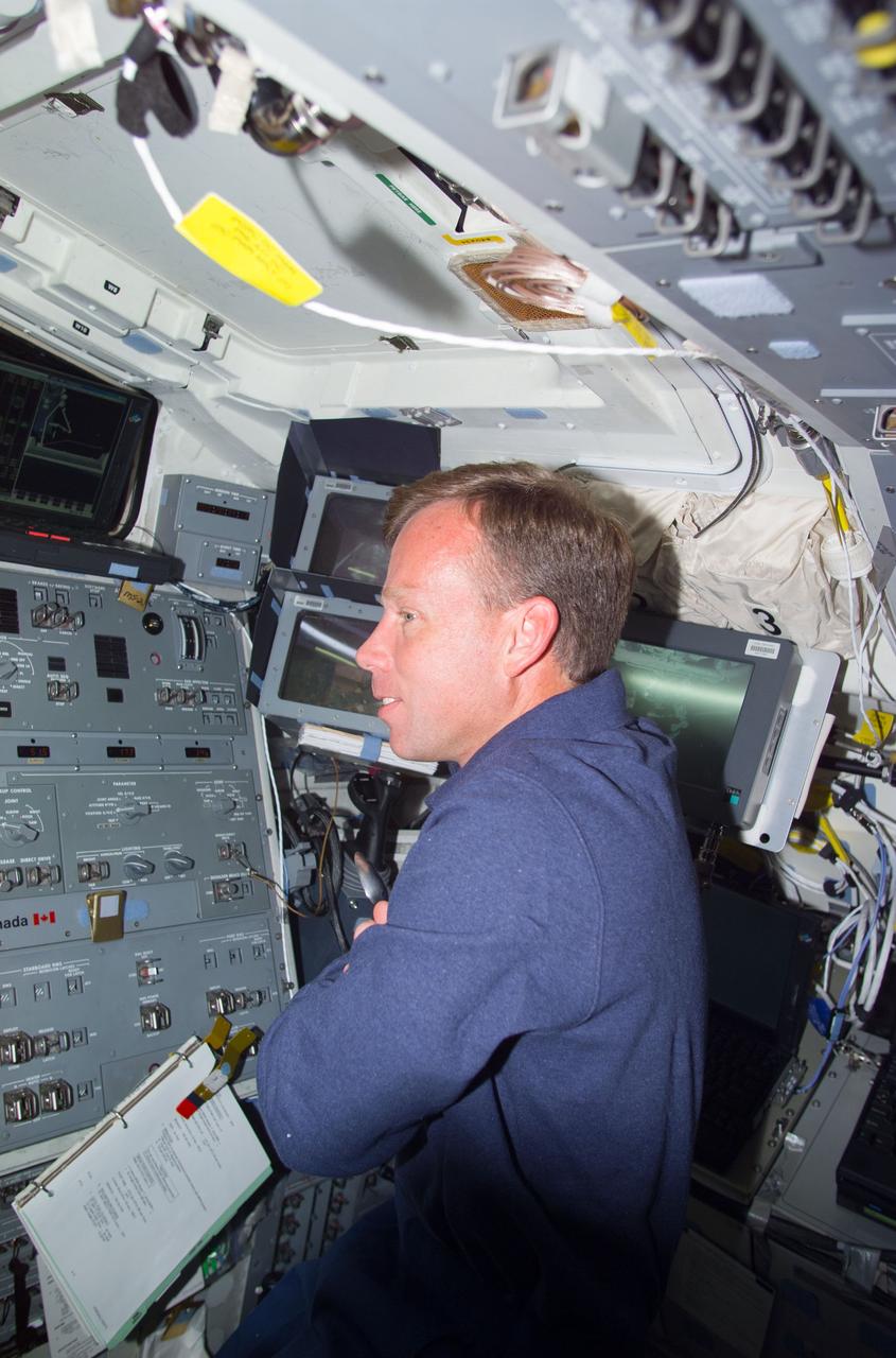 STS104-E-5227 (21 July 2001) --- Working in tandem with the station's Canadarm2 operator and Expedition Two flight engineer James S. Voss, astronaut Steven W. Lindsey, STS-104 commander, supports  mission specialists Michael L. Gernhardt  and James F. Reilly during the final of three STS-104 space walks. Lindsey is on the aft flight deck of the Space Shuttle Atlantis, while Voss worked at controls in the Destiny laboratory.  The extravehicular activity (EVA) was partly devoted to the attachment of a new nitrogen supply tank to the shell of the new Airlock Quest.  This photo was recorded with a digital still camera.