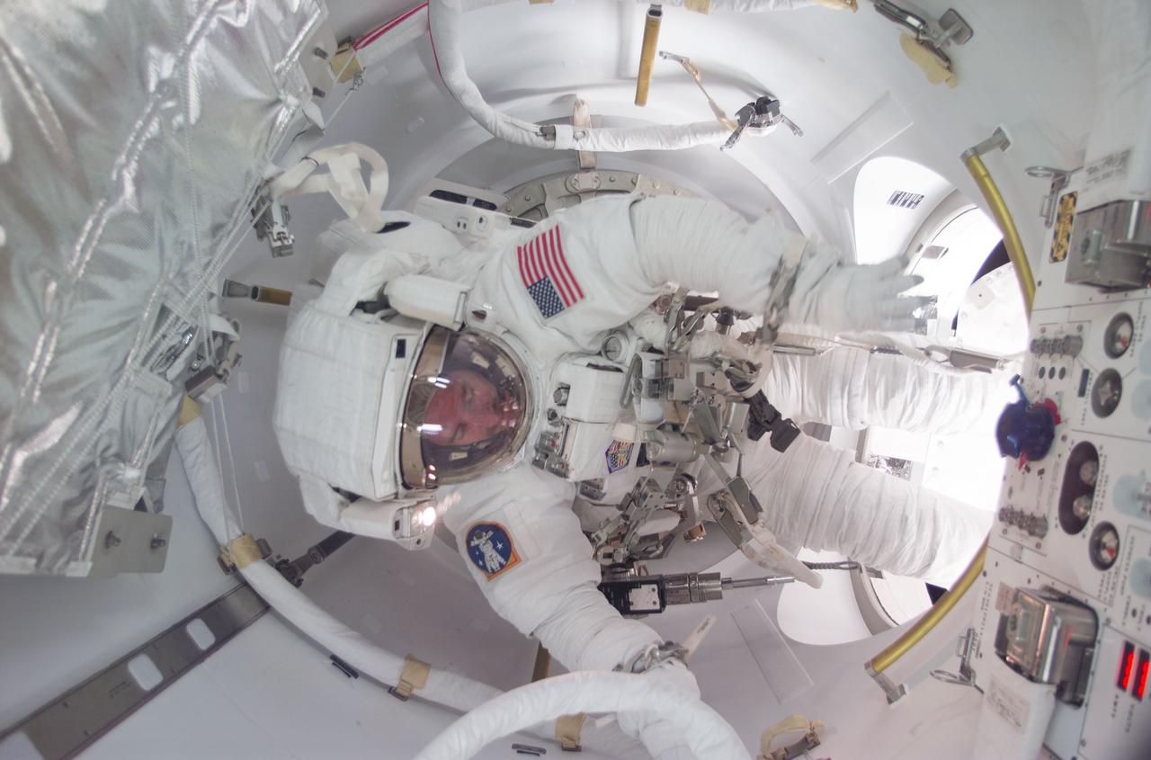 STS104-E-5237 (20 July 2001) ---  Astronaut James F. Reilly participates in a bit of space history as he joins astronaut Michael L. Gernhardt (out of frame) in utilizing the new Quest airlock for the first ever space walk to egress from the International Space Station (ISS).  The two STS-104 mission specialists were scheduled to attach a fourth and final supply tank to the airlock&#0146;s exterior, and move on to some get-ahead tasks made possible when they were able to  attach a bonus third tank during an earlier space walk. Tasks added to the final space walk include an inspection of one of the station&#0146;s solar array swivels and inspection of the Floating Potential Probe that measures plasma levels around the solar arrays.  The image was recorded with a digital still camera.