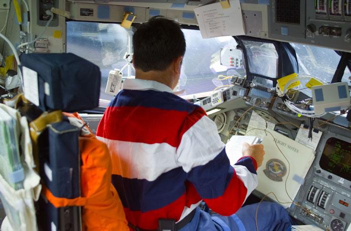 STS105-E-5001 (10 August 2001) ---  Astronaut Scott J. Horowitz, STS-105 commander, checks flight notes at the commander's station on the flight deck of the Earth-orbiting Space Shuttle Discovery.  The image was recorded with a digital still camera.