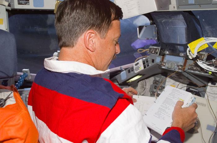 STS105-E-5002 (10 August 2001) ---  Astronaut Scott J. Horowitz, STS-105 commander, checks flight notes at the commander's station on the flight deck of the Earth-orbiting Space Shuttle Discovery.  The image was recorded with a digital still camera.