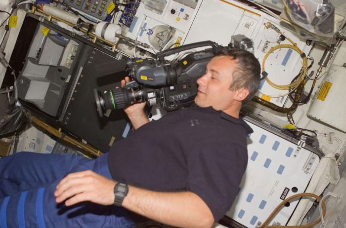 STS105-E-5007 (10 August 2001) --- Cosmonaut Vladimir Dezhurov of Rosaviakosmos uses a video camcorder  on the mid deck of the Space Shuttle Discovery during the first day in space for the STS-105 crew members and the  Expedition Three crew.  Dezhurov will serve as flight engineer aboard the International Space Station (ISS).  This  image was recorded with a digital still camera.