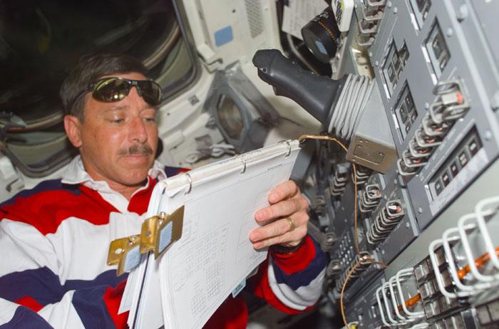 STS105-E-5061 (12 August 2001) --- Astronaut Scott J. Horowitz, STS-105 mission commander, looks over a checklist on the aft flight deck of the Space Shuttle Discovery during rendezvous operations with the International Space Station (ISS).  The image was recorded with a digital still camera.