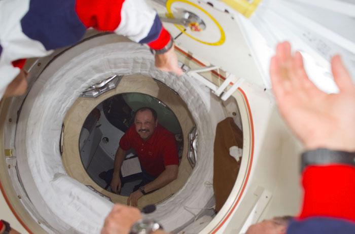 STS105-E-5094 (12 August 2001) --- Yury V. Usachev of Rosaviakosmos, Expedition Two mission commander, can be seen through the recently opened airlock hatch of Space Shuttle Discovery as he welcomes the STS-105 and Expedition Three crews.  This image was taken with a digital still camera.