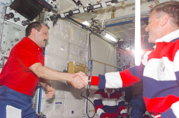 STS105-E-5102 (12 August 2001) --- Yury V. Usachev of Rosaviakosmos (left), Expedition Two mission commander, greets Frank L. Culbertson, Jr., Expedition Three mission commander, with a handshake in the U.S. Laboratory.  Culbertson, accompanied by cosmonauts Mikhail Tyurin and Vladimir N. Dezhurov, will be replacing Usachev and astronauts Susan J. Helms and James S. Voss and will spend the next four months aboard the International Space Station (ISS).  This image was taken with a digital still camera.