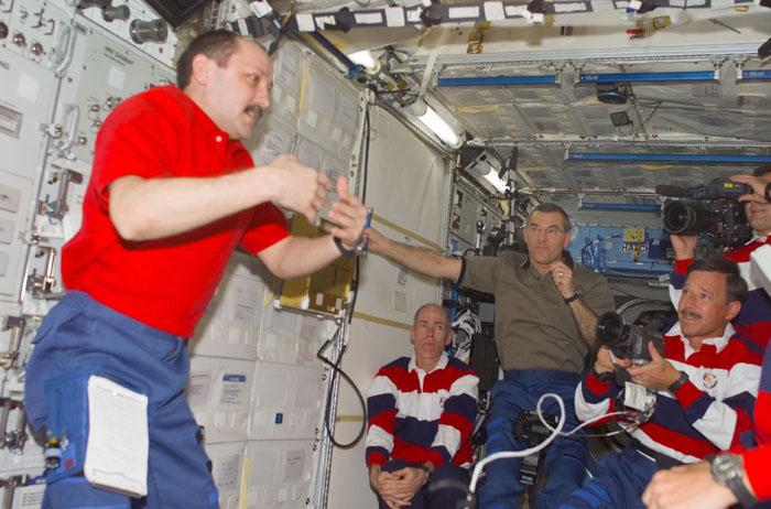 STS-105-E-5103 (12 August 2001) --- Yury V. Usachev of Rosiaviakosmos (left), Expedition Two mission commander, addresses the visiting STS-105 and Expedition Three crews in the U.S. Laboratory.  Also visible, from left to right, are Daniel T. Barry, STS-105 mission specialist, James S. Voss, Expedition Two flight engineer, Scott J. Horowitz, STS-105 commander - holding a camcorder, cosmonaut Vladimir N. Dezhurov, Expedition Three flight engineer - holding a high definition video camera.  This image was taken with a digital still camera.