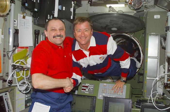STS105-E-5119 (12 August 2001) --- Yury V. Usachev of Rosaviakosmos (left), Expedition Two mission commander, gives Frank L. Culbertson, Jr., Expedition Three mission commander, a warm reception in the Zvezda Service Module. Culbertson, accompanied by cosmonauts Mikhail Tyurin and Vladimir N. Dezhurov, will be spending the next four months aboard the International Space Station (ISS).  This image was taken with a digital still camera.