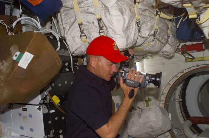 STS105-E-5187 (14 August 2001) --- Astronaut Frederick W. (Rick) Sturckow, STS-105 pilot, uses a camcorder to document supplies and hardware on the mid deck of the Space Shuttle Discovery, which is currently docked to the International Space Station (ISS).  The image was recorded with a digital still camera.
