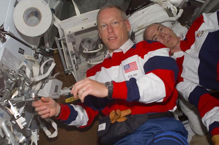 STS105-E-5217 (15 August 2001) --- Onboard the Space Shuttle Discovery, astronauts Patrick G. Forrester (left) and Daniel T. Barry check out some of the equipment they will be working with  on their scheduled space walk in less than 24 hours.  The image was recorded with a digital still camera.