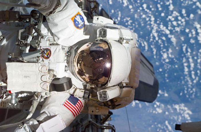 STS105-E-5231 (16 August 2001) ---  The helmet and torso of astronaut Patrick G. Forrester are featured in this digital still camera's view recorded during early stages of the first space walk on STS-105. Most of the cargo bay of the Space Shuttle Discovery and the aft cabin is reflected in the helmet visor.