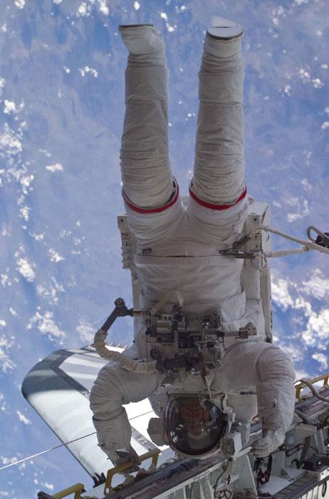 STS105-E-5236 (16 August 2001) ---  Astronaut Daniel T. Barry appears to be hanging by his hands from the cargo bay's portside longerons on the Space Shuttle Discovery during the initial space walk on STS-105.  Barry is actually tethered to the shuttle at his waist. The image was recorded with a digital still camera.