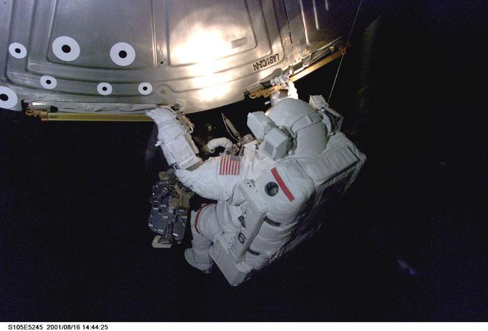 STS105-E-5245 (16 August 2001) ---  Astronaut Daniel T. Barry maneuvers  along the handrails on the Destiny Laboratory during the first of two  scheduled STS-105 space walks.  The image was recorded with a digital still camera.