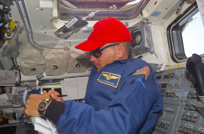 STS105-E-5283 (16 August 2001) --- Astronaut Frederick W. (Rick) Sturckow, STS-105 pilot, reviews a procedures checklist on the aft flight deck of the Space Shuttle Discovery which is currently docked to the International Space Station (ISS). This image was taken with a digital still camera.