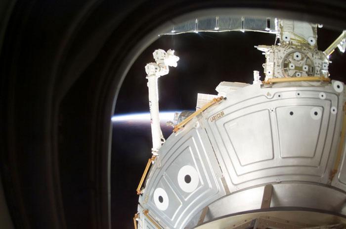 STS105-E-5341 (17 August 2001) --- Backdropped by a sunset, the Canadarm2 / Space Station Remote Manipulator System (SSRMS) is being operated by a crewmember from the International Space Station (ISS). This image was taken with a digital still camera through a window on the flight deck of the Space Shuttle Discovery by a STS-105 crewmember.