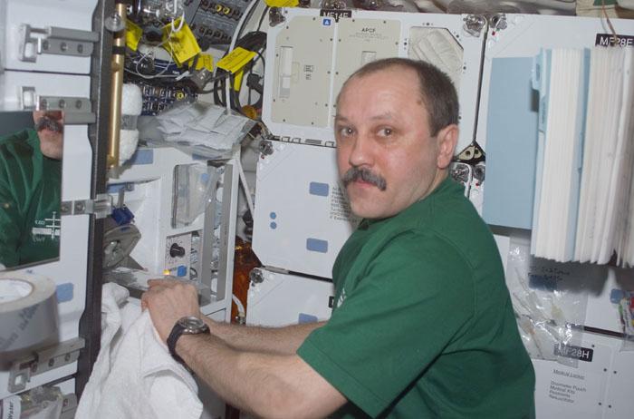 STS105-E-5409 (20 August 2001) --- Yury V. Usachev of Rosaviakosmos, Expedition Two mission commander, prepares a drink for himself at the galley on the middeck of the Space Shuttle Discovery.  Usachev and fellow Expedition Two crewmembers Susan J. Helms and James S. Voss are returning to Earth after completing their five month mission aboard the International Space Station (ISS).  This image was taken with a digital still camera.