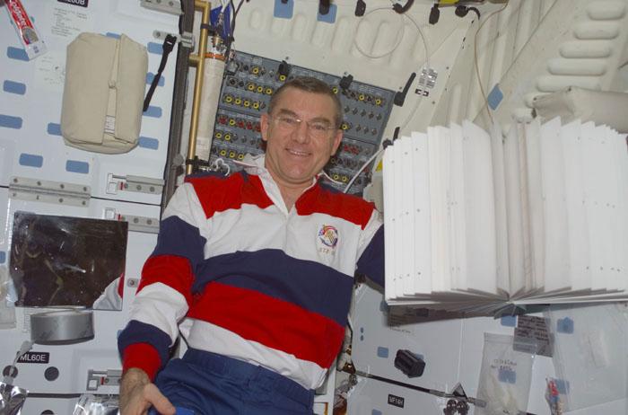 S105-E-5411 (20 August 2001) --- James S. Voss, Expedition Two flight engineer, poses by some fanned-out computer paper on the middeck of the Space Shuttle Discovery.  Voss and fellow Expedition Two crew members Susan J. Helms and cosmonaut Yury V. Usachev are returning to Earth after completing their five month mission aboard the International Space Station (ISS).  This image was taken with a digital still camera.