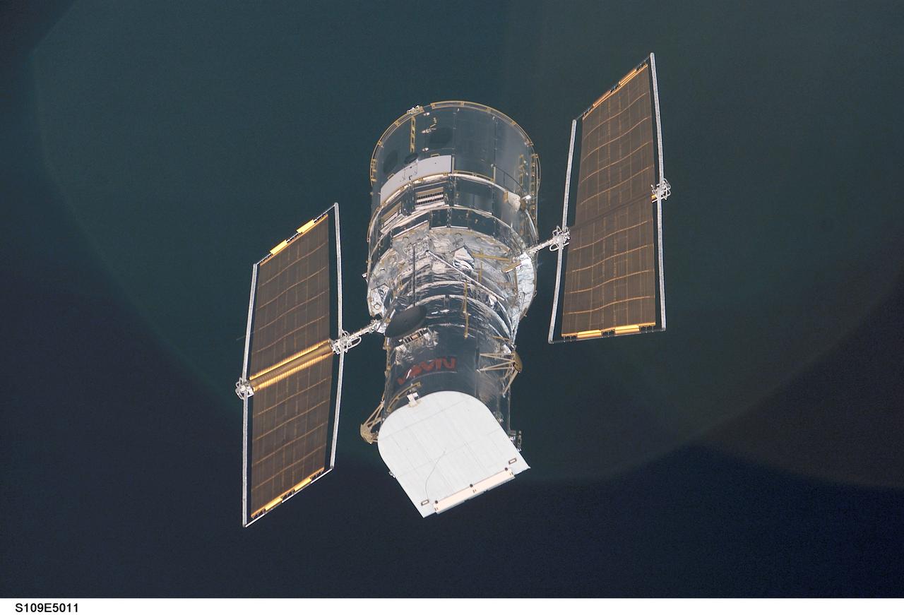 STS109-E-5011 (3 March 2002) --- The Hubble Space Telescope is backdropped against black space as the Space Shuttle Columbia, with a crew of seven astronauts on board, eases closer and closer in order to latch its 50-foot-long robotic arm onto a fixture on the giant telescope. As Columbia flew 350 miles above the Pacific Ocean Southwest of Mexico, with astronaut Nancy J. Currie, mission specialist, in control of the arm and astronaut Scott D. Altman, mission commander, at the  controls of the shuttle, the crew went on to capture the Hubble. The image was one of a series recorded with a digital still camera.