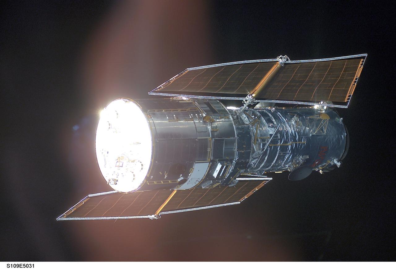 STS109-E-5031 (3 March 2002) --- The Hubble Space Telescope is backdropped against black space as the Space Shuttle Columbia, with a crew of seven astronauts on board, eases closer and closer in order to latch its 50-foot-long robotic arm onto a fixture on the giant telescope. As Columbia flew 350 miles above the Pacific Ocean Southwest of Mexico, with astronaut Nancy J. Currie, mission specialist, in control of the arm and astronaut Scott D. Altman, mission commander, at the  controls of the shuttle, the crew went on to capture the Hubble. The image was one of a series recorded with a digital still camera.