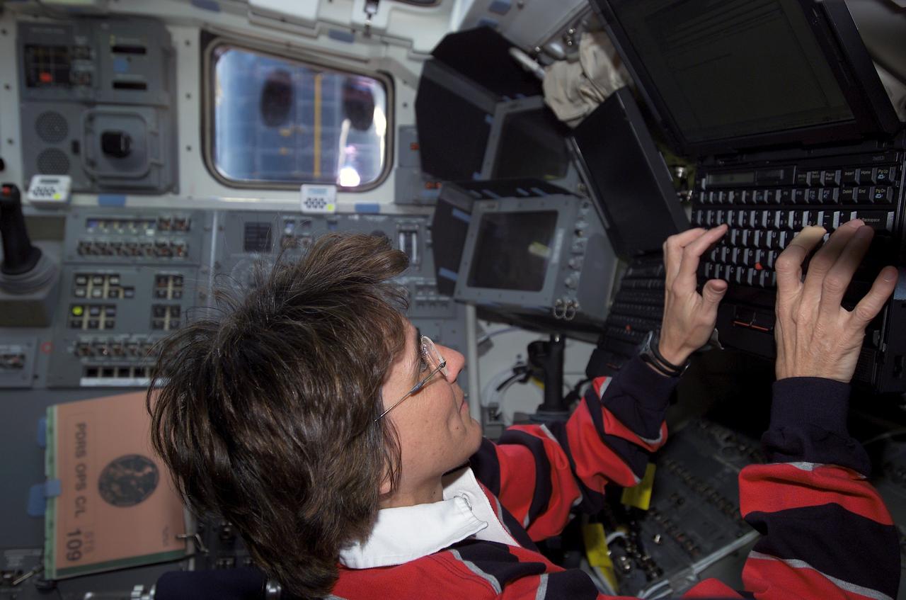 STS109-E-5291 (1-12 March 2002) --- Astronaut Nancy J. Currie, STS-109 mission specialist, works with Payload and General Support Computers (PGSC) on the mid deck of the Space Shuttle Columbia. The image was taken with digital still camera.