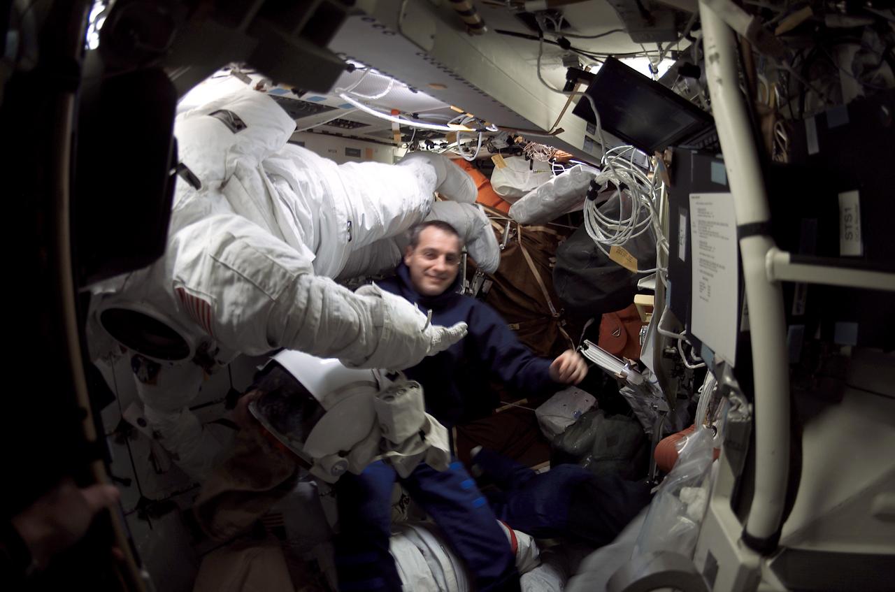 STS109-E-5326 (1-12 March 2002) --- Astronaut Richard M. Linnehan, STS-109 mission specialist, is photographed among Extravehicular Mobility Unit (EMU) space suits and stowage bags on the mid deck of the Space Shuttle Columbia. The image was taken with digital still camera.
